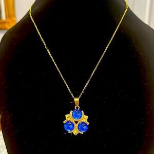 Elegant Gold Necklace with Royal Blue Gemstones, in a triangular pattern.